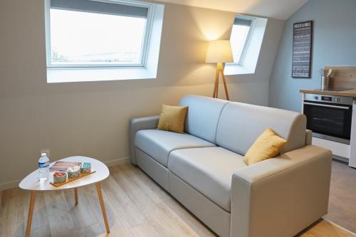 图尔昆LocationsTourcoing - Le Famelart的客厅配有沙发和桌子