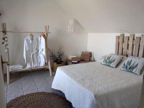 圣保罗La Plaine-itude & Spa的一间卧室,配有床和一些衣服