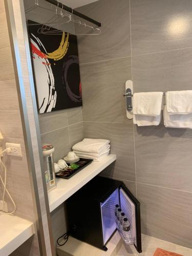 Dahan花莲七星海酒店的浴室设有电视,位于架子上