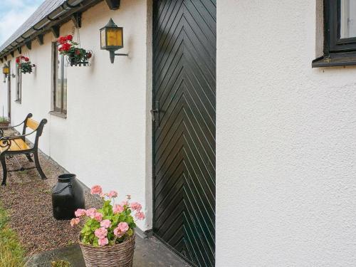 拉霍尔姆6 person holiday home in Laholm的一座带黑白围栏和鲜花的房子