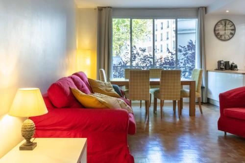 巴黎Paris City - Spacious 3 rooms flat for families - 3 minutes from metro station的客厅配有红色的沙发和桌子