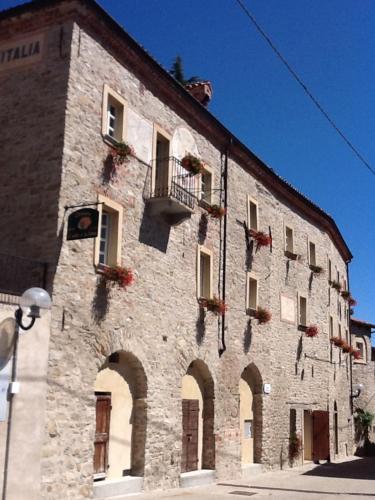 Cerretto Langhe迪莫拉斯托里科罗曼迪卡伊尔索莱伊娜卢纳乡村民宿的一座带窗户和阳台的大型石头建筑