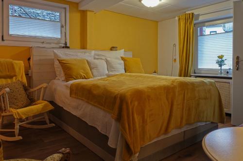 蒙绍HIER & JETZT in Monschau City的一间卧室配有一张带黄色毯子的大床