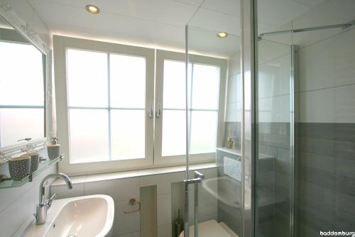 栋堡Zuidstraat 3a - baddomburg的一间带玻璃淋浴和水槽的浴室