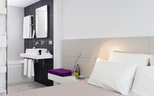 伊西莱穆利诺伊斯莱斯利诺巴黎诺富特套房酒店的一间卧室配有床、水槽和镜子