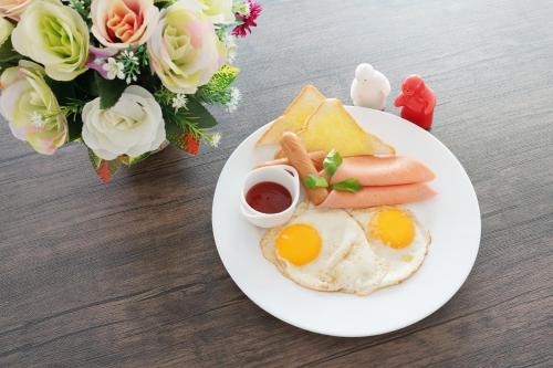 色军NK Residence Sakon Nakhon的包括鸡蛋和烤面包的早餐盘