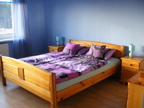 库多瓦-兹德鲁伊Pokoje gościnne Norbu的一间卧室配有一张带紫色床单和枕头的木床。
