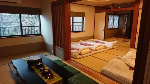 名古屋Show和の宿つちや～豊臣の隠れ茶の間～的一间设有两张床和一张桌子的房间