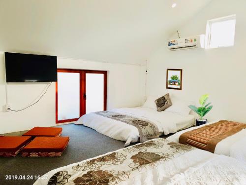 洞海RiverView HomeStay的一间卧室配有两张床和一台平面电视