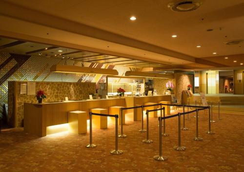 热海阿塔米新富士屋酒店的大堂设有酒吧,前面设有凳子