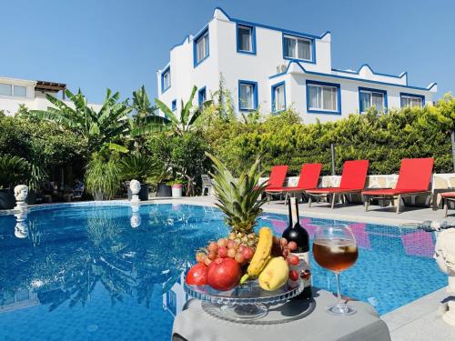 博德鲁姆阿屯博德鲁姆酒店的一张桌子,上面放着一碗水果和一杯葡萄酒