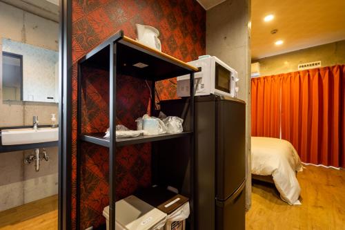 那霸Hotel Little Island Okinawa Matsuyama的带冰箱的客房和1间带1张床的卧室