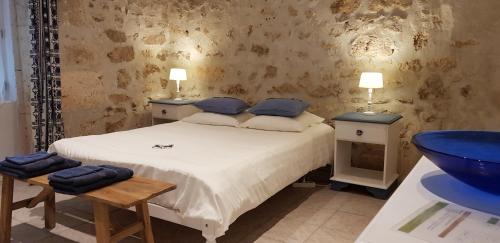 ChervalLes chambres de la grange的一间卧室配有一张带两张桌子和水槽的床