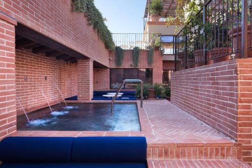佛罗伦萨Hotel Calimala的砖墙砖砌的建筑中的游泳池