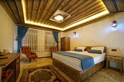 格雷梅Termessos Hotel的一间卧室配有一张床、一张桌子和一把椅子