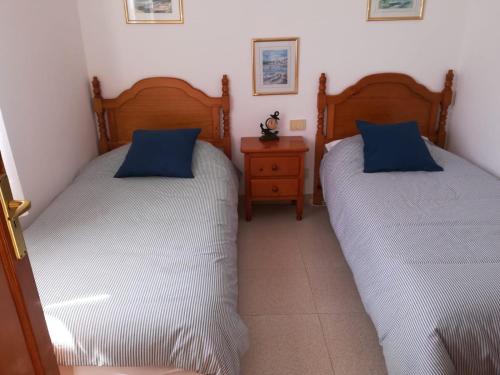 塞博河畔卡莱塔Casa El Salao的一间卧室设有两张床和床头柜