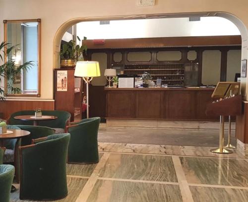 的里雅斯特米兰酒店的一间带桌椅和钢琴的餐厅