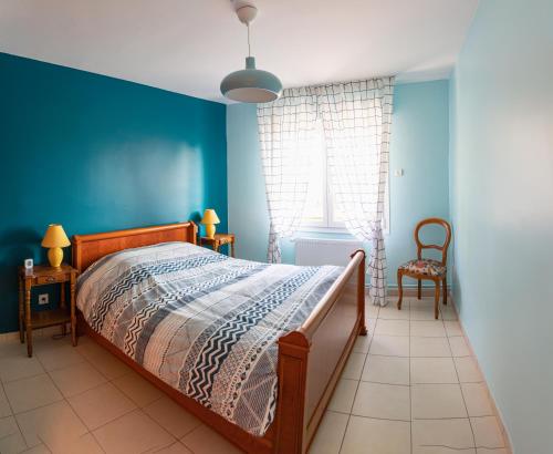 RenwezPaisible Maison entière 140m2 avec véranda vue sur la campagne的一间卧室设有一张床和蓝色的墙壁