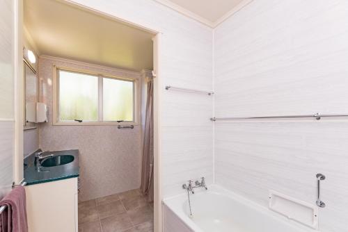 派西亚Te Ra Waitangi的白色的浴室设有浴缸和水槽。