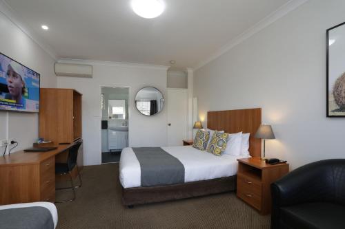 塔姆沃思卡德曼汽车旅馆的酒店客房设有一张大床和一张书桌。