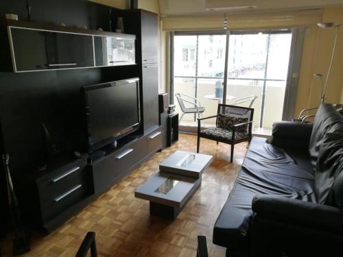 布宜诺斯艾利斯BairesTop con 2 dormitorios y estacionamiento的带沙发和大电视的客厅