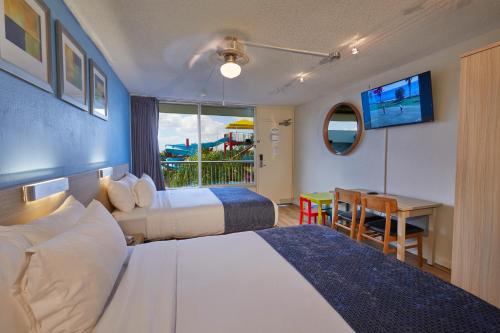 基西米火烈鸟水上乐园度假酒店的酒店客房设有两张床和一张桌子。