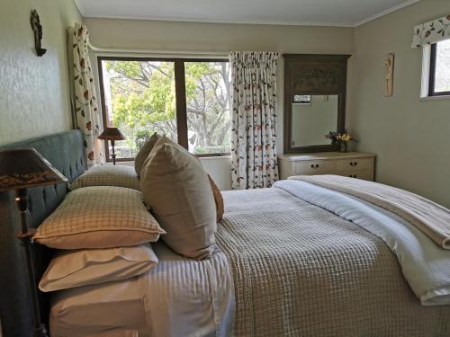 纳皮尔美好生活住宿加早餐旅馆的卧室配有带枕头的床铺和窗户。