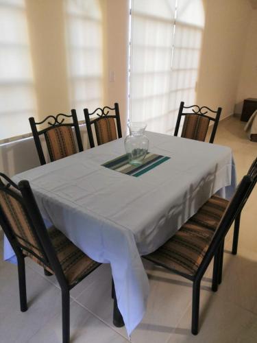 蒙特雷KIA - PESQUERIA - AEROPUERTO MONTERREY a的餐桌、白色桌布和椅子