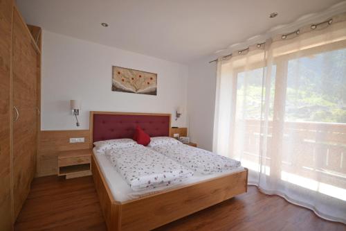 圣莱奥纳尔多因帕西里亚Residence Apartment Talblick的一间卧室设有一张床和一个大窗户