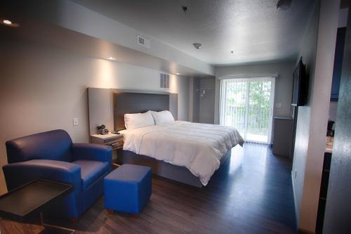 圣罗伯Z Loft Extended Stay Hotel的一间卧室配有一张床和一张蓝色椅子
