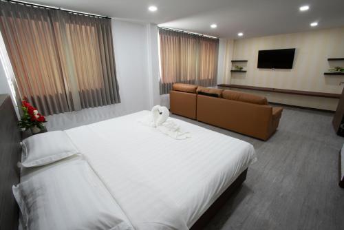 色军NK Residence Sakon Nakhon的酒店客房设有一张大床和一张沙发。