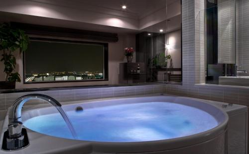 浦安东京湾浦安布莱顿酒店的带电视的浴室设有大浴缸