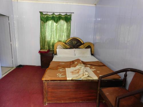 BālākotHamaliya Hotel & Restaurant的一间小卧室,配有床和窗户