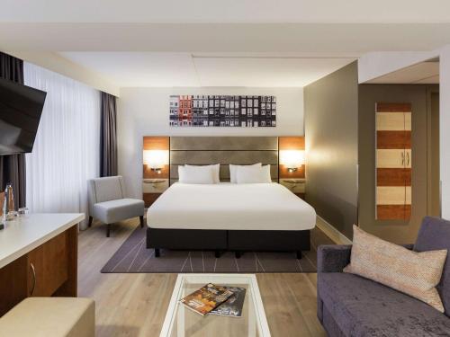 阿姆斯特丹阿姆斯特丹西美居酒店的酒店客房,配有床和沙发