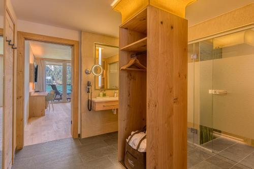 纳瑟尔文勒haldensee - Naturerlebnis und Wellnesshotel的带淋浴、盥洗盆和镜子的浴室