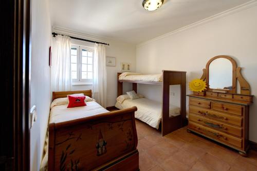 托莱多FINCA EL PIRUETANO的一间卧室配有两张双层床、梳妆台和镜子
