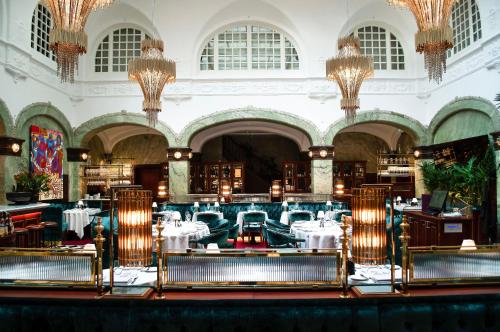 斯德哥尔摩Bank Hotel, a Member of Small Luxury Hotels的用餐室配有桌椅和吊灯。