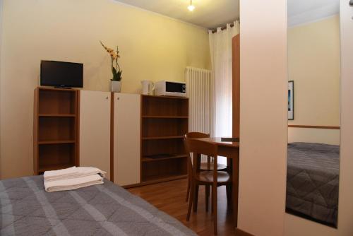 莫利亚诺威尼托阿尔巴卡热图酒店的小房间设有一张床、一张桌子和一间卧室