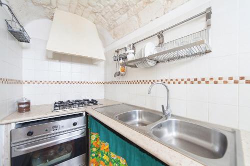 奥斯图尼Casa Meravigliosa的厨房配有水槽和炉灶