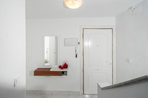 阿尔姆尼卡Casa Chana的白色的走廊,设有白色的门和桌子