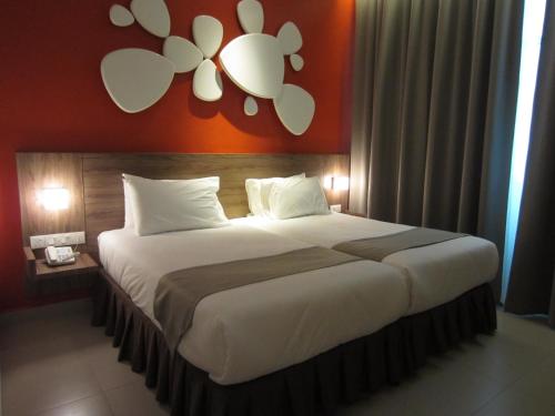 斯里伊斯兰德D酒店的一间卧室配有一张带橙色墙壁的大床