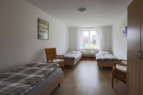 HavekostGästehaus Höltig的客房设有两张床、椅子和窗户。