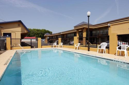 阿拉楚阿Americas Best Value Inn Alachua的一座带椅子的大型游泳池和一座建筑