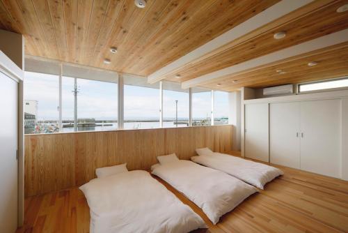 Motoshin渚泊魚津丸的一张位于带大窗户的房间内的床铺
