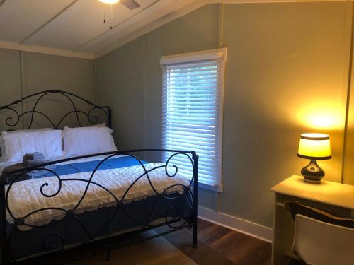 博福特Beaufort SC New Renovation, Close to Parris Island, Historic Downtown, Beautiful Beaches, Sleeps 8的一间卧室配有一张床和一扇带灯的窗户