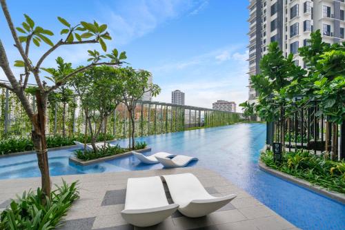 Kampong Baharu Sungai WayHighPark Suites in Petaling Jaya, Kelana Jaya by Plush的一座带两个白色长椅的建筑中的游泳池