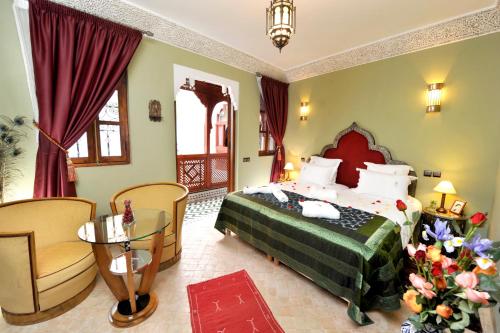 马拉喀什Riad Belle Epoque的一间卧室配有一张床、一把椅子和一张桌子