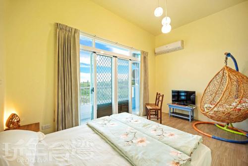 Huxi彩色渔之居民宿的一间卧室设有一张床和一个大窗户