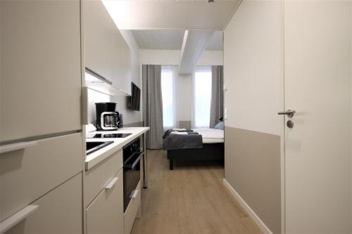 瓦尔考斯Forenom Aparthotel Varkaus的一间白色的小厨房,在房间内配有一张床