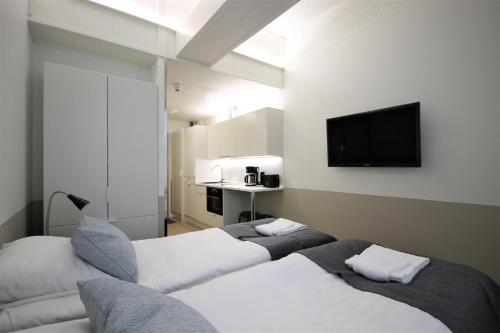 瓦尔考斯Forenom Aparthotel Varkaus的酒店客房设有两张床和一台平面电视。